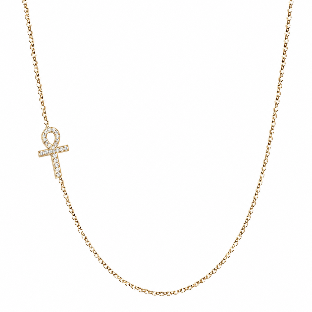A delicate gold chain necklace featuring an ankh pendant paved with small clear stones, displayed against a solid white background.