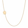A delicate gold chain necklace featuring a small, polished gold four-leaf clover charm, displayed against a solid white background.