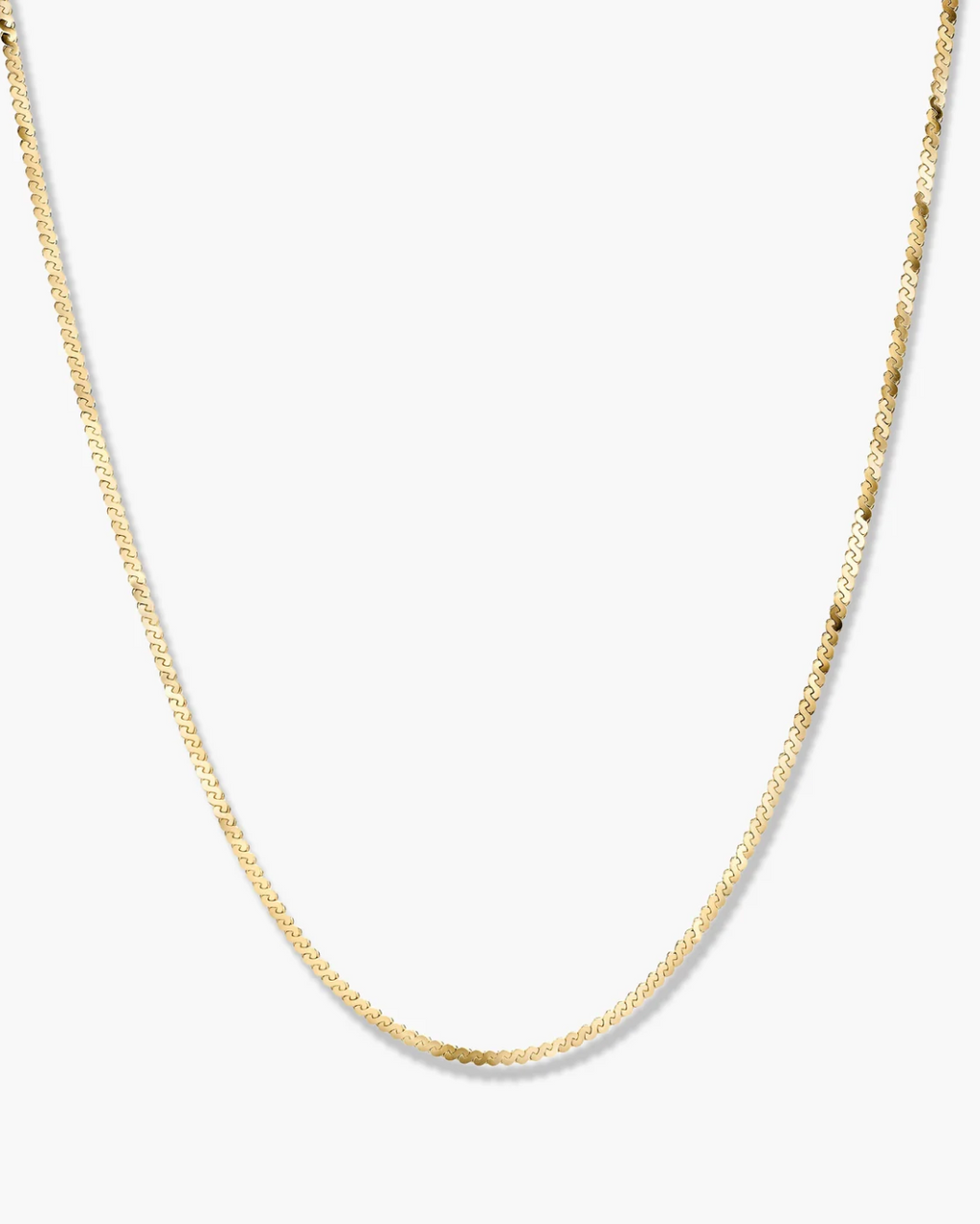 Gold chain necklace on a light gray background