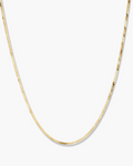 Gold chain necklace on a light gray background