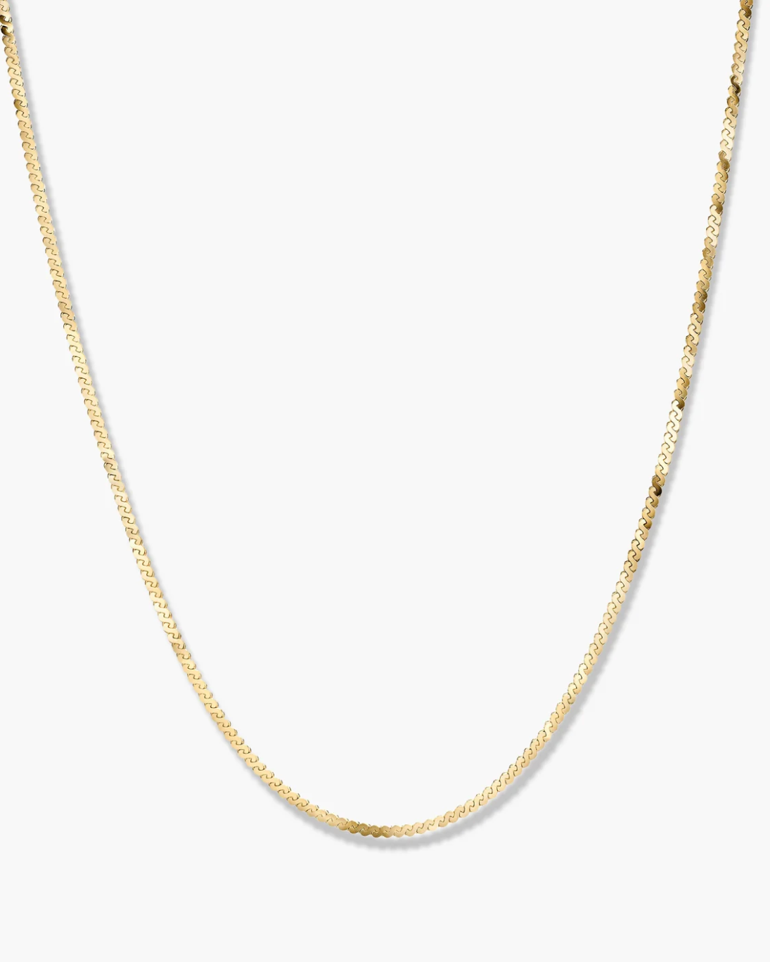 Gold chain necklace on a light gray background