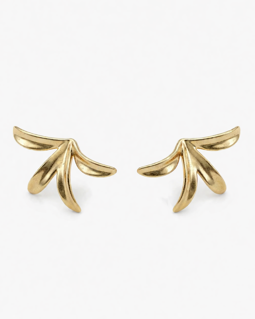 Gold leaf-shaped earrings on a white background