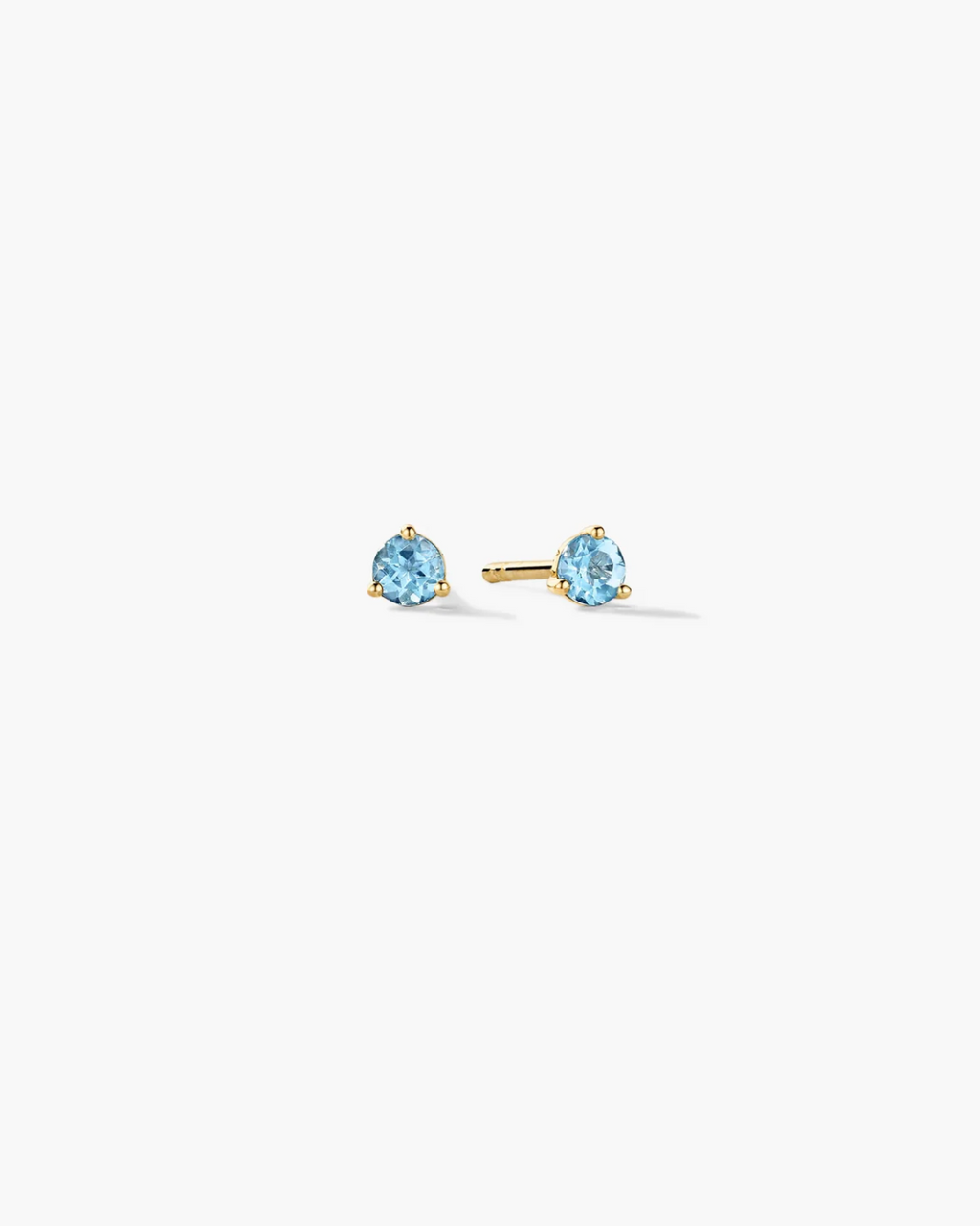 Gold stud earrings with blue gemstones on a white background