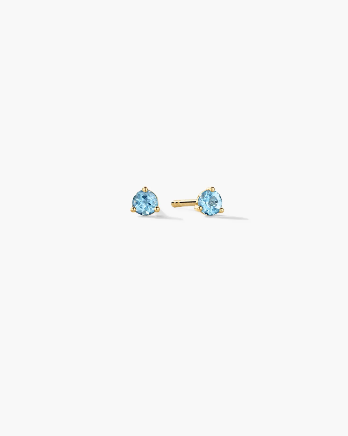 Gold stud earrings with blue gemstones on a white background