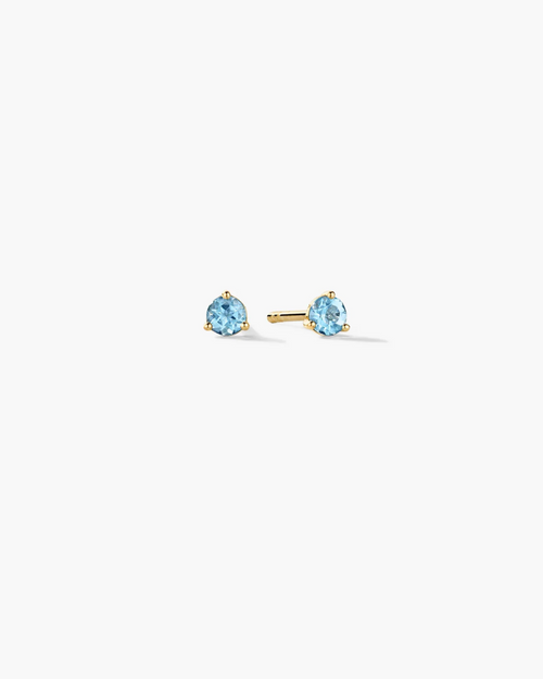 Gold stud earrings with blue gemstones on a white background